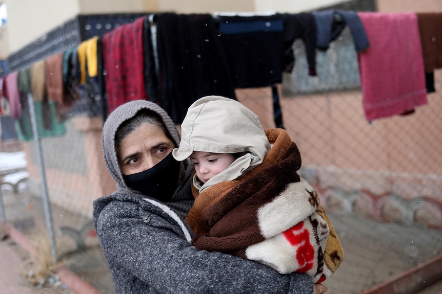 Baby Sohail's grandmother holds him in her arms as they leave Safi's house, January 8, 2022.