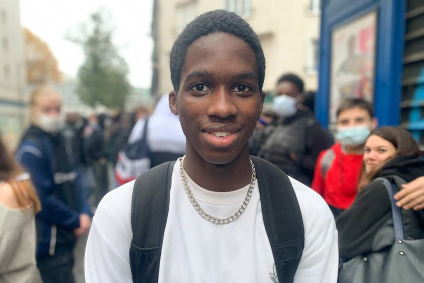 A 16-year-old French boy smiles and poses for the camera.