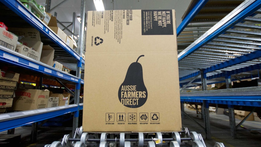 A large box for Aussie Farmers Direct sits in between shelves, waiting to be packed.