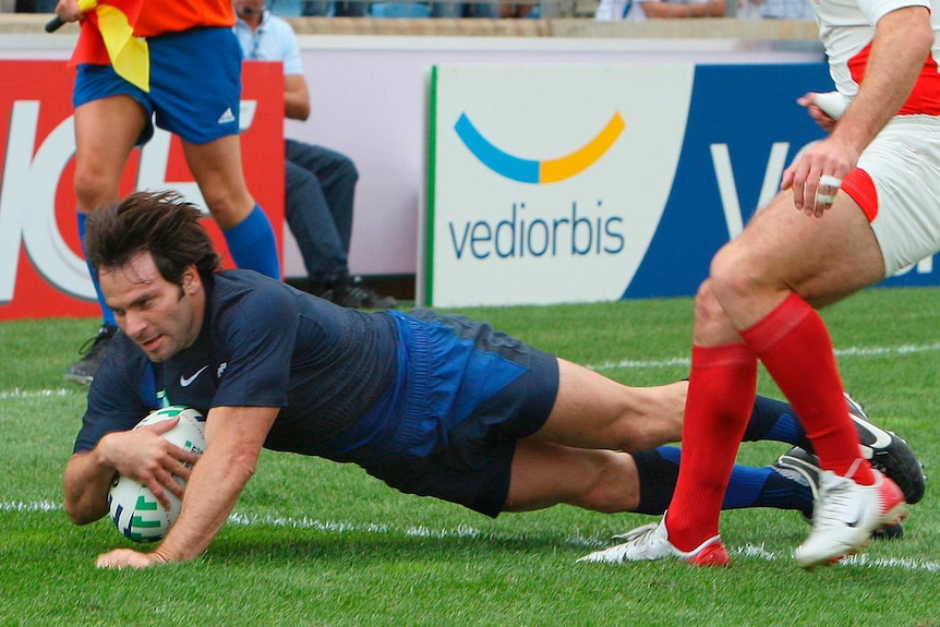 Christophe Dominici dives over the tryline to score for France