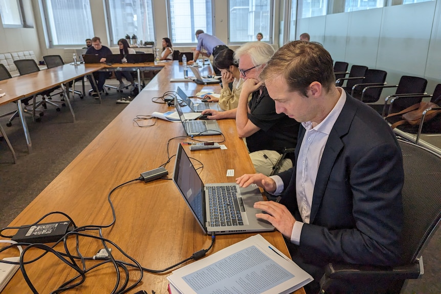 Journalists on laptops filing their stories after the embargo lifts at the RBA Financial Stability Review lock-up