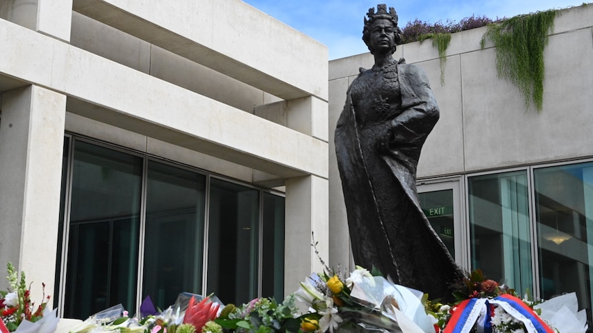 Flowers have been laid underneath a statue of Queen Elizabeth