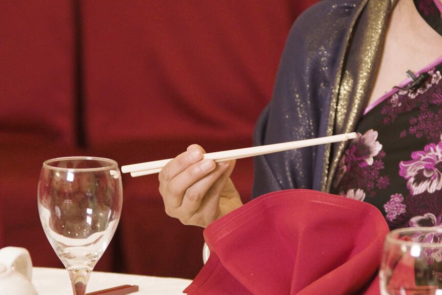 Close up of hand picking up chopsticks