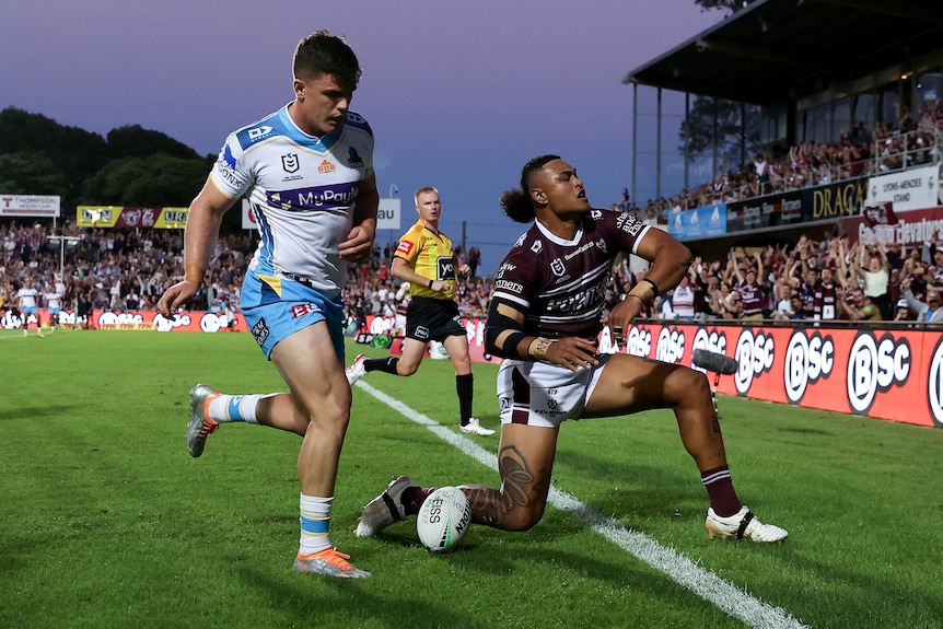     A Manly player scores a try against the Titans during an NRL game
