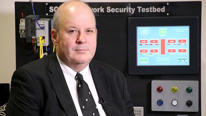 Cyber security expert Craig Valli seated in front of an electronic screen.