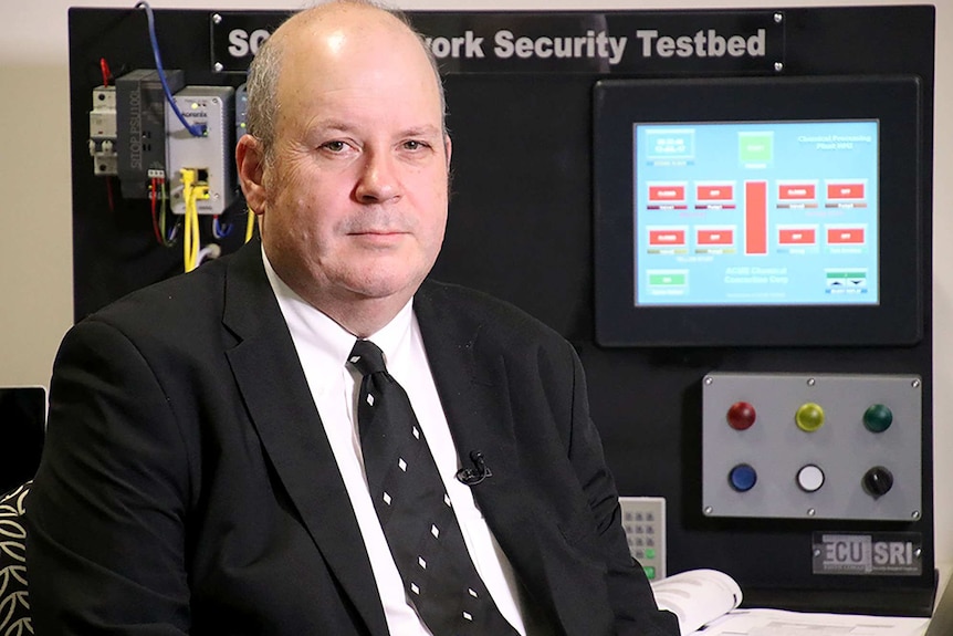 Cyber security expert Craig Valli seated in front of an electronic screen.