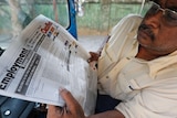 A man in Sri Lanka reads a newspaper in a taxi