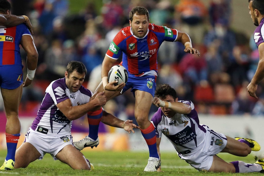 Cameron Smith and Cooper Cronk attempt to tackle Tyrone Roberts