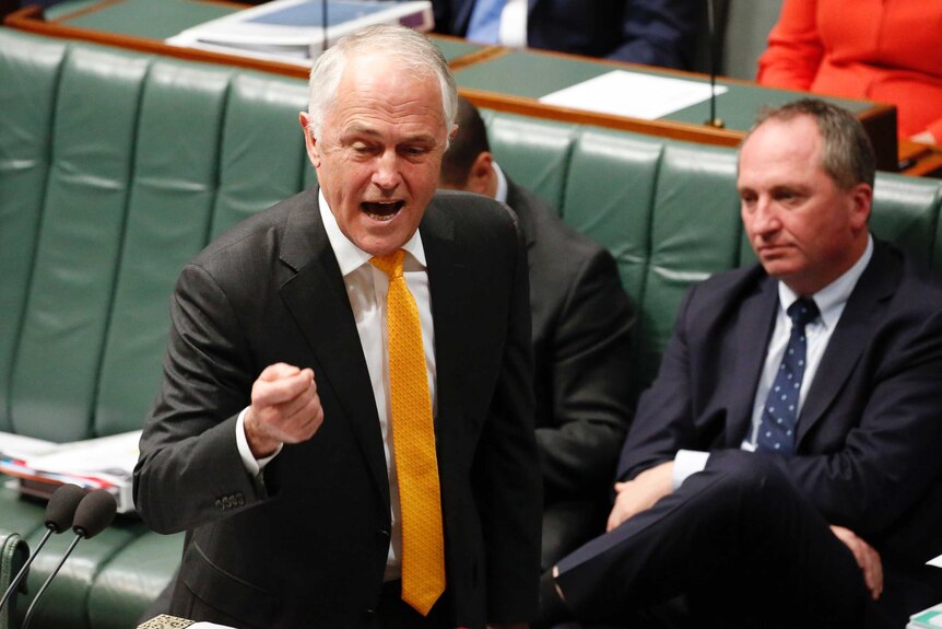 Malcolm Turnbull, wearing a yellow and orange tie, gestures during Question Time. He appears to be yelling