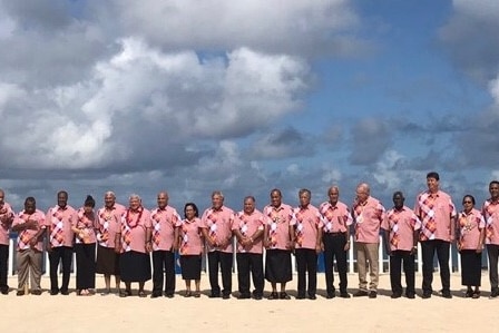 líderes de las islas del pacífico parados juntos en una playa 
