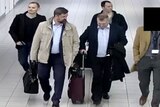 Four men walk through the airport