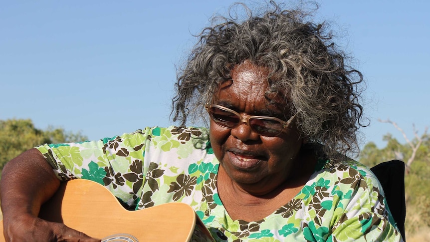 Olive Knight playing the guitar