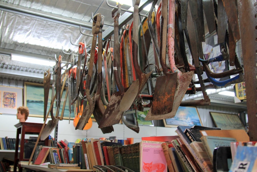 Shovels hanging above books in the tip shop