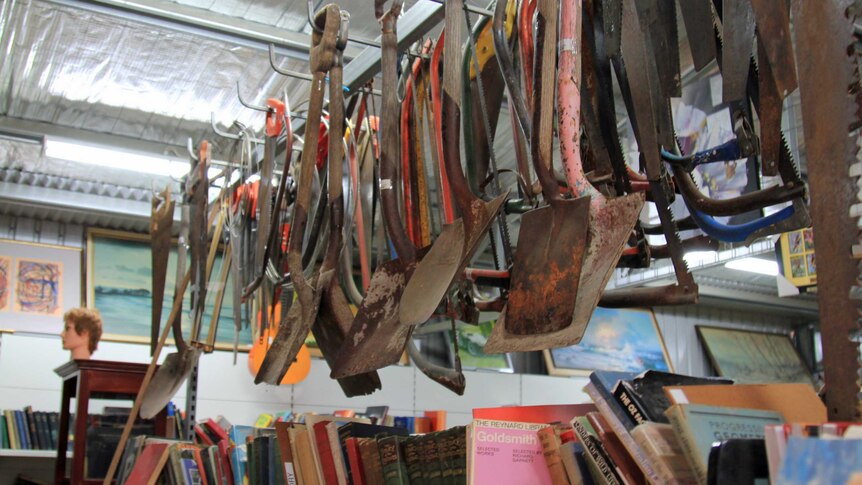 Shovels hanging above books in the tip shop