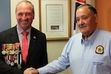 Barnaby Joyce, smiling while wearing military medals, shakes the hand of Bob Chapman from the RSL.