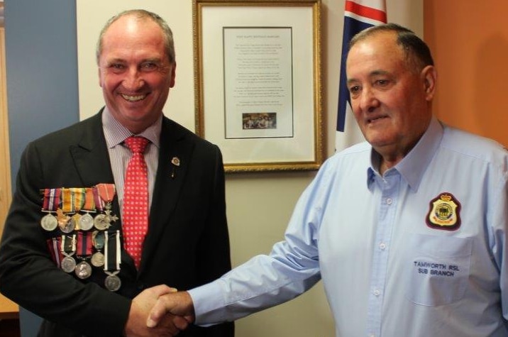 Barnaby Joyce, smiling while wearing military medals, shakes the hand of Bob Chapman from the RSL.
