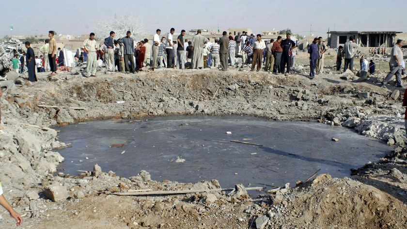 Residents gather around a crater after a bomb attack near Mosul, north of Baghdad on August 10, 2009