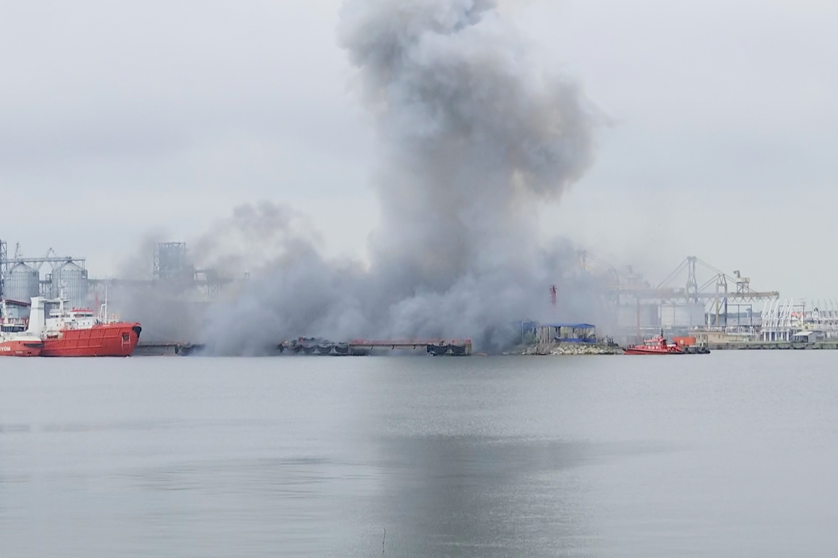 smoke lingers after an explosion in a sea port