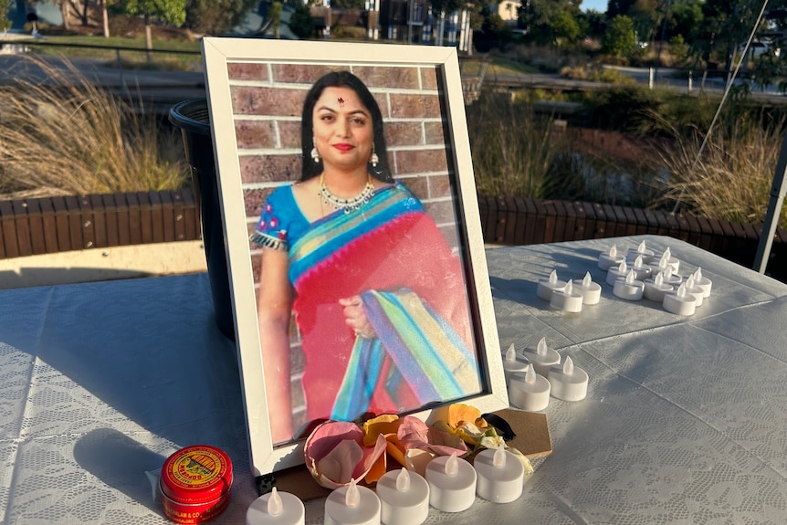 A photo of Chaithanya Madhagani on a table with battery operated candles as part of a vigil.