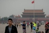 A plain-clothes policeman follows suspected journalists in Tiananmen Square.