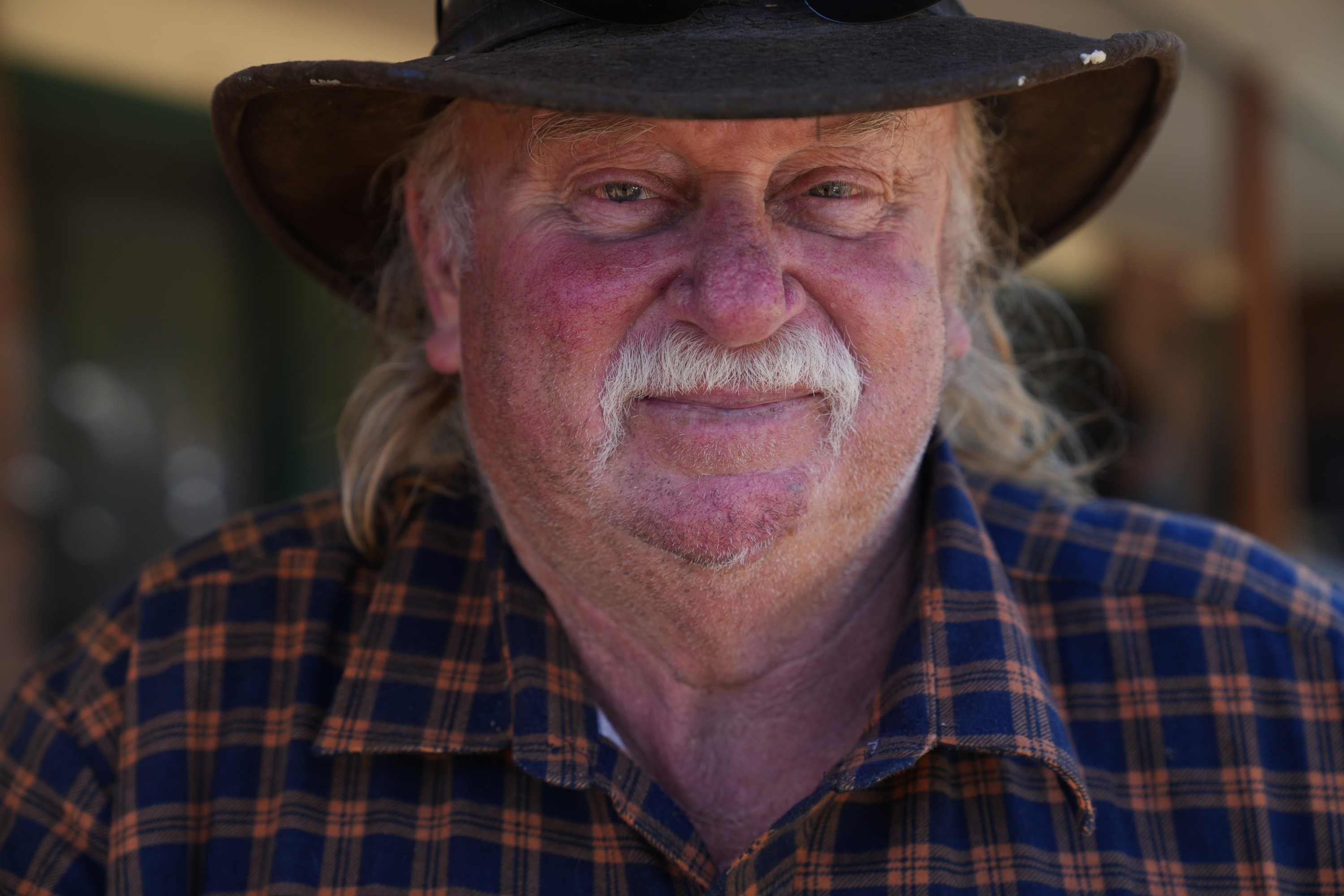 一位头发花白、留着胡须、戴着宽边帽的老人。