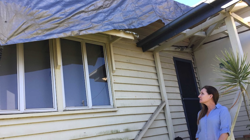 Mel Deacon looks at her damaged house