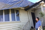 Mel Deacon looks at her damaged house