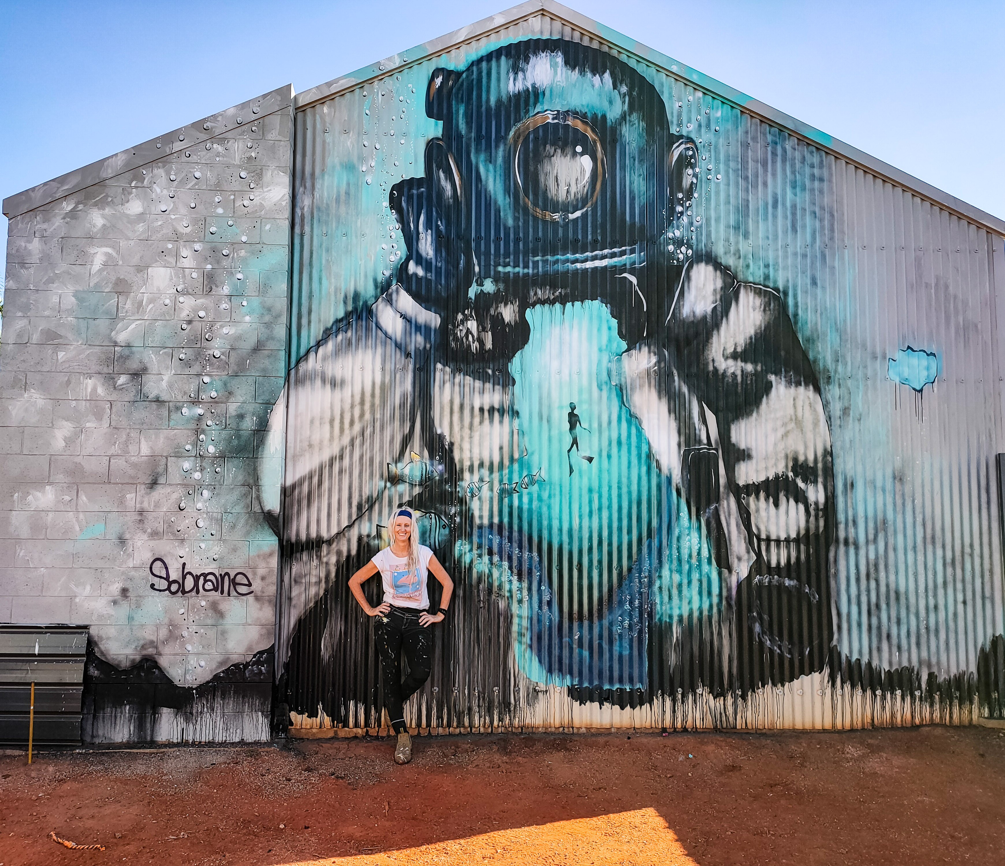 A woman in front of a colourful mural