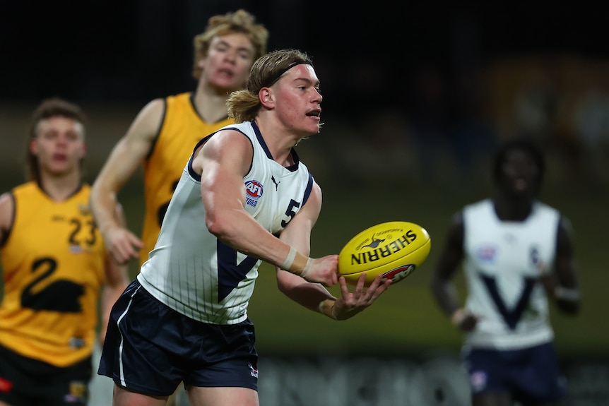 Harley Reid handballs while playing for Vic Country