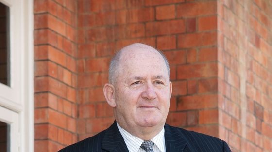 Peter Cosgrove stands against a brick background