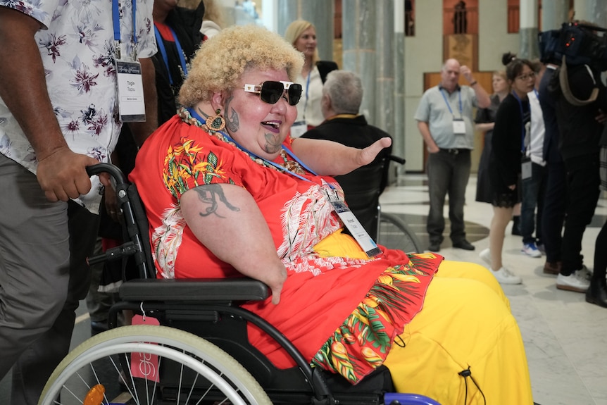 A thalidomide survivor in a wheel chair sits inside Parliament House