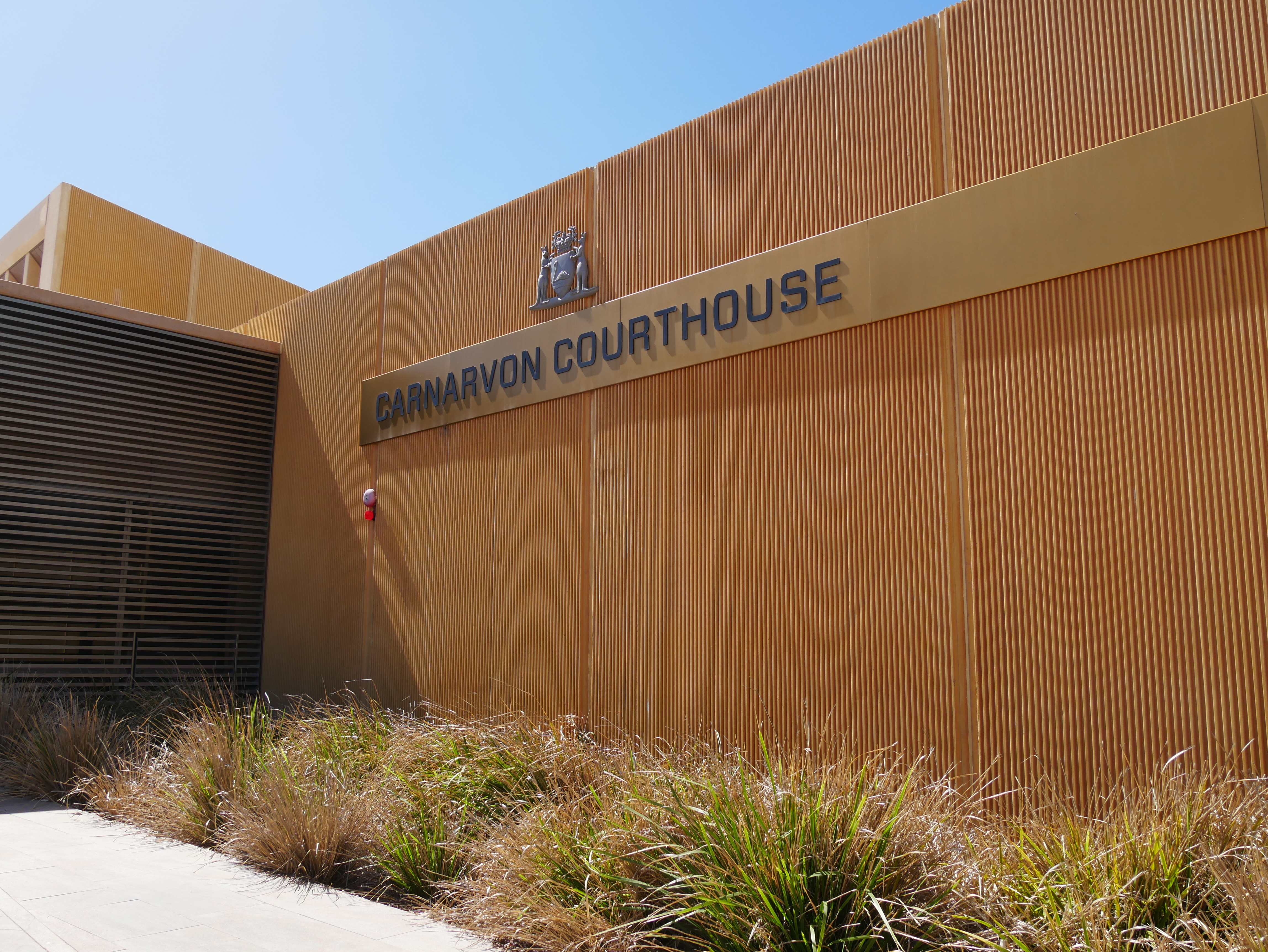 A wide shot of orange building with sign reading Carnarvon Courthouse