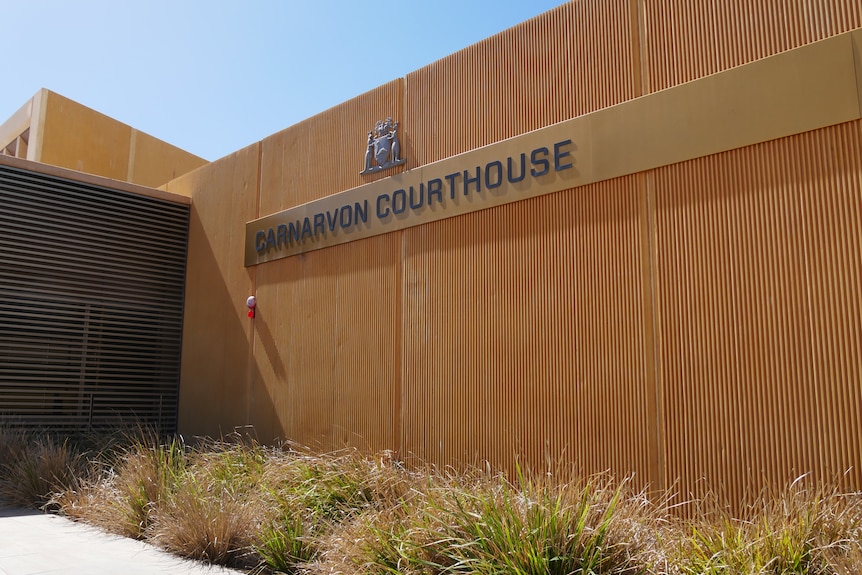A wide shot of orange building with sign reading Carnarvon Courthouse