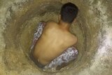 An asylum seeker on Manus Island digging in the hope of finding water.