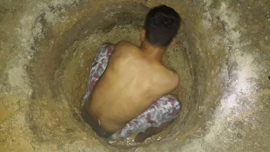 An asylum seeker on Manus Island digging in the hope of finding water.