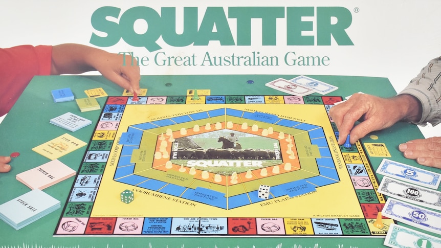 A cover of a board game with hands playing .