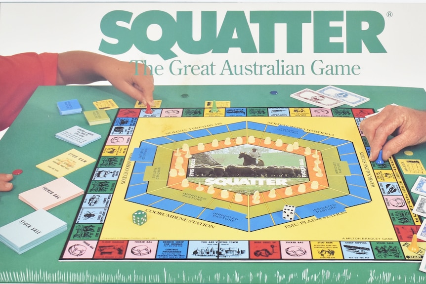 A cover of a board game with hands playing 