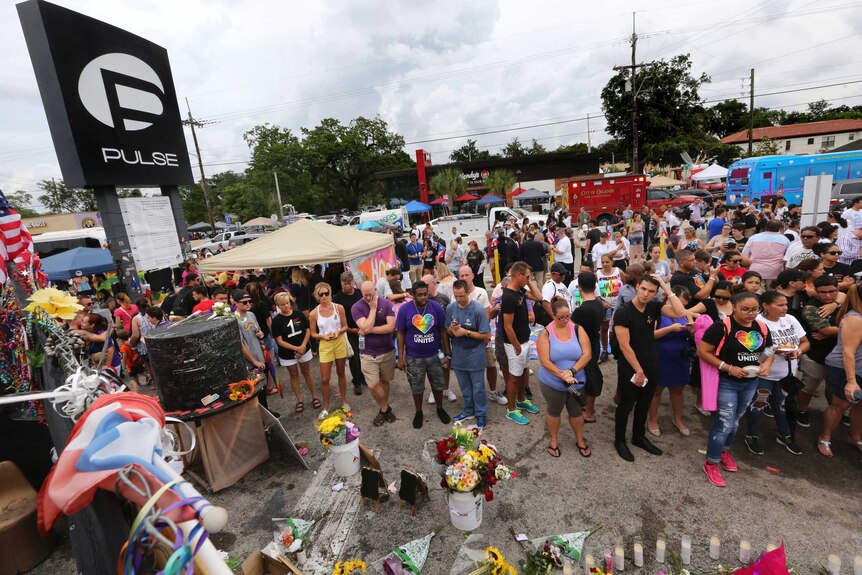 People gather during a community gathering at the Pulse nightclub memorial site in Orlando