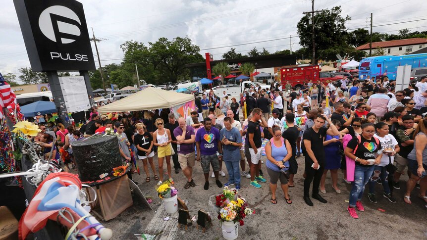 People gather during a community gathering at the Pulse nightclub memorial site in Orlando