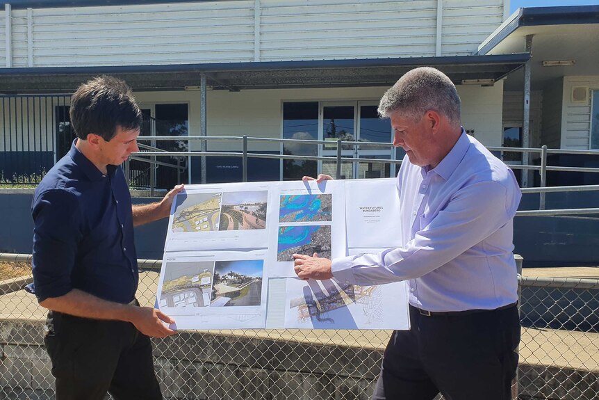 Minister Sterling Hinchliffe inspects the design plans for the Bundaberg East Levee