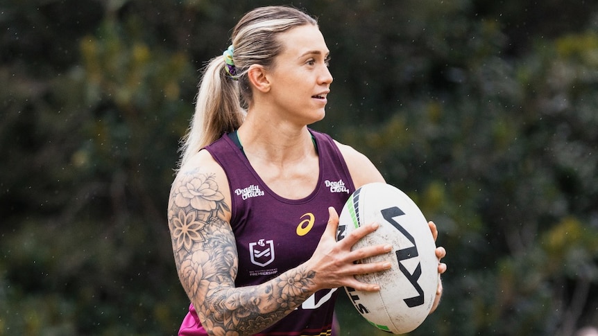 Brisbane Broncos winger Julia Robinson wears a tank top and holds the ball in two hands at NRLW training.