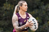 Brisbane Broncos winger Julia Robinson wears a tank top and holds the ball in two hands at NRLW training.