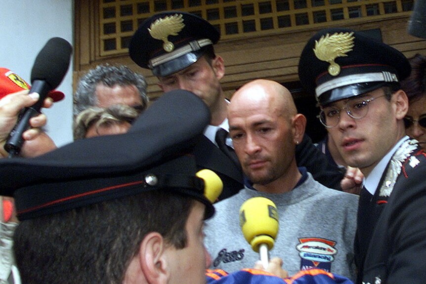 Marco Pantani is surrounded by people