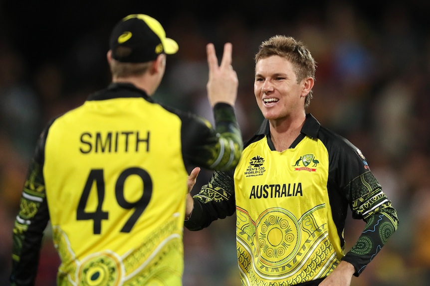Adam Zampa smiles and Steve Smith holds up two fingers