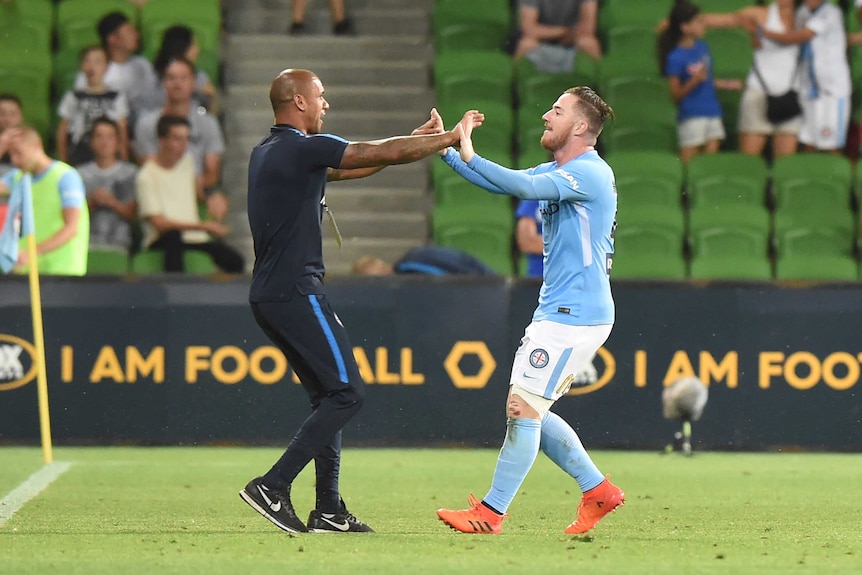 Ross McCormack and Patrick Kisnorbo embrace following a Melbourne City goal against Wellington Phoenix.