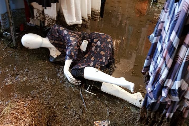 A shop mannequin lies amidst a shop damaged by a flood.