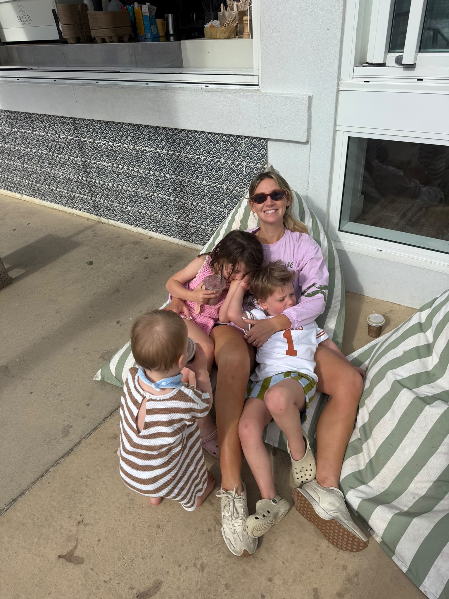a mum and three kids sitting on a bean bag