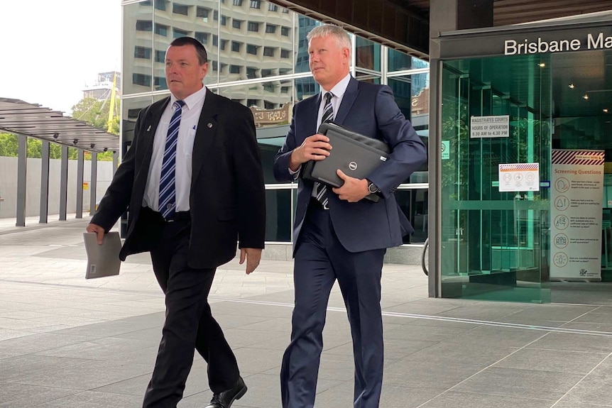 Two men in suit leave court.