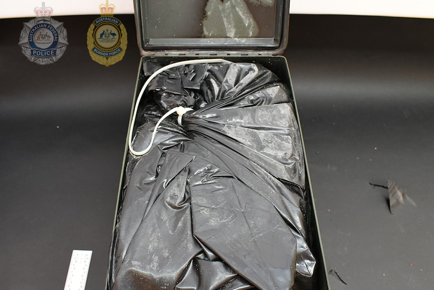 A plastic bag filled with drugs inside a metal case