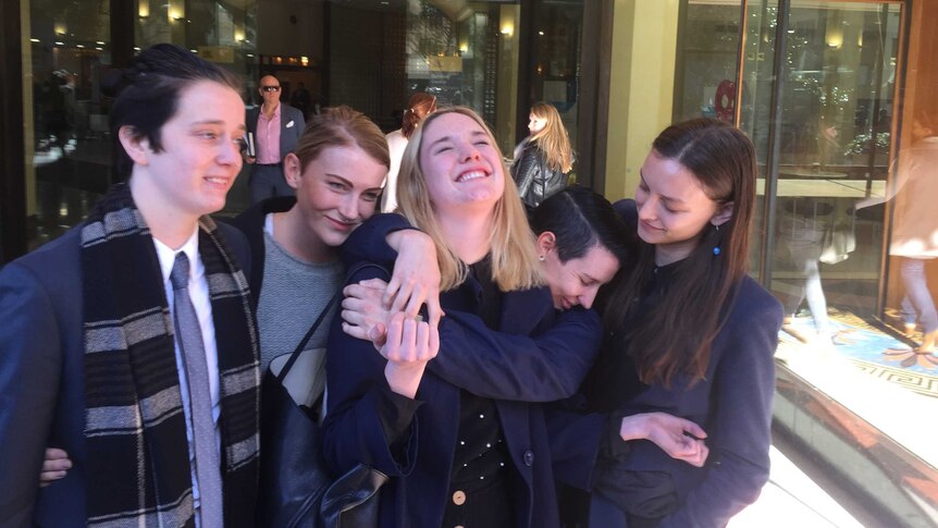 Paloma Brierly Newtown surrounded by four friends laughing and looking elated.